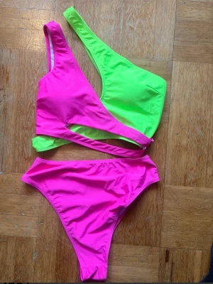 Neonrosa och limegrön bikini i stl L - En splitter ny bikini från Shein i stl L, i cerise och neon gul. Har aldrig använt den inte ens provat utan den var ett felköp som jag glömde att returnera. Hämtas på Södermalm i Stockholm eller skickas till dig. Du bestämmer. Maila mig vid frågor.  Med vänlig hälsning, Fanny. 