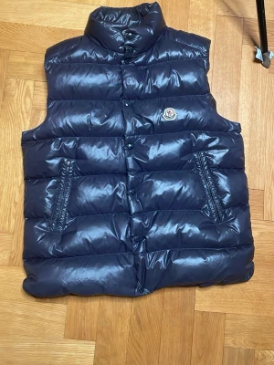 Mörkblå dunväst från Moncler - Moncler tib gelet down väst, jätte bra skick 9/10 använd max tre gånger. Moncler size 4 (large)