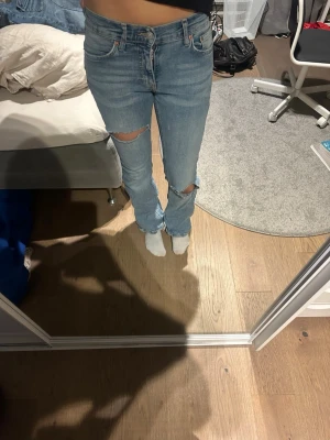 Ljusblå ripped bootcut jeans - Snygga Lågmidjade jeans från Gina. Har klippt hålen själv. Tveka inte på att höra av er vid frågor 