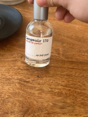 Langmuir 17.0 Eau de Parfum - Säljer en oanvänd Langmuir 17.0 är en parfym från one bold chemist. Nypris 349, mitt pris 199!  Flaskan är transparent med en silverfärgad spraykork och har en minimalistisk vit etikett med svart och röd text. Parfymen har en modern och stilren design som passar perfekt på hyllan.