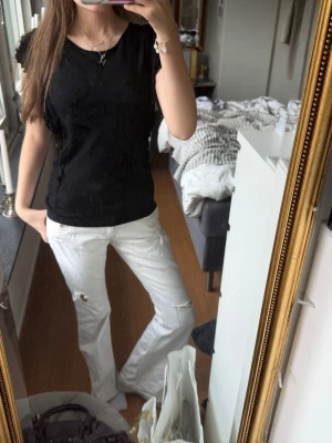 Svart topp med volangärmar! - Snygg svart topp med volangdetaljer på ärmarna. Klassisk rund halsringning och normal passform. Perfekt att styla med jeans eller kjol för en trendig look passar för både festliga tillfällen och som en vardags look! Jätte luftig och skönt material💘
