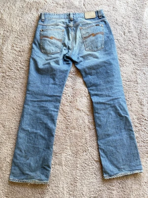 Nudie Bootcut Ola - Modell: Bootcut Ola👖  Färg: Blå/Ljus blå🎨  Storlek: W34 L32🪡🧵  Mått: W43cm L105cm Benöppning: 23cm Lår:28cm📐