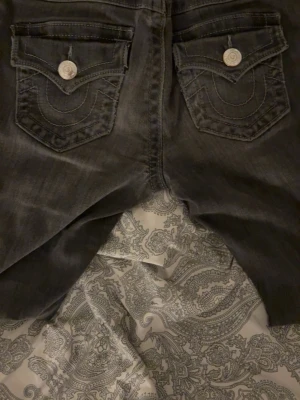 Gråa/svart mid rise bootcut jeans från true religion  - Säljer ett par svarta/gråa  mid rise bootcut jeans från true religion. Använt några gånger men börjat tröttna på dom. Köptes för 1200❤️