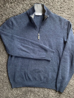 Gran Sasso Half-Zip i Kashmir & Ull - Exklusiv Gran Sasso half-zip i väldigt hög kvalité. Blå färg med snygg ljusgrå insida på kragen. Snygg design som passar till allt! 🧵 Märke: Gran Sasso 📏 Storlek: 50 - M  🧩 Material: 80% Ull, 10% Kashmir, 10% Viskos 📐 Mått: Längd: 62 cm Bröst: 52 cm Axelvidd: 41 cm Ärmlängd: 62 cm ✅ Skick: Grade B - Fint slick! Har använts men har inga defekter eller skador alls! Bilderna säger allt!  ✨ Detaljer: Made in Italy, lyxig känsla rakt igenom. 💰 Nypris: Ca 2500 kr ‼️Skickas snabbt‼️