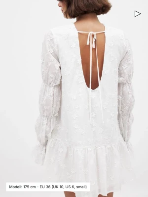 Vit klänning med ärmdetalj - Superfin vit klänning med broderade blommor, långa ärmar och öppen rygg med snörning. 🎀 Klänningen är helt ny med prislapp kvar! En bästsäljare från NA-KD. Perfekt till sommaren eller studenten! 