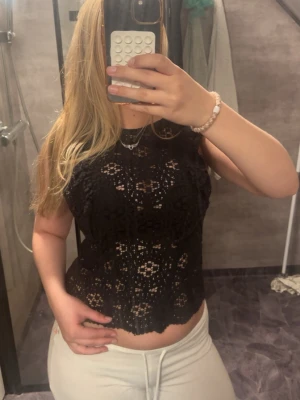 Svart spetstopp - Snyggt svart linne med blommig spets och genombrutet mönster. Croppad modell med ärmlös design och rund halsringning. Säljer pga att jag inte använder längre 💞