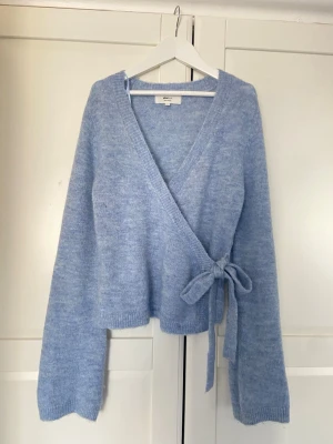 Supersöt vårig stickad tröja - Säljer en supersöt stickad tröja från Gina tricot. Använd max 2 gånger. Perfekt ljusblå färg nu till våren. Den har även en liten detalj där man knyter den vid sidan för att få en så fin passform. 