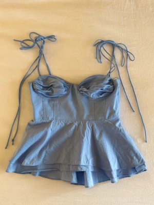 Trendig zara topp - Supersöt blå linnetopp från Zara med volang. Små fläckar finns men inget man tänker på