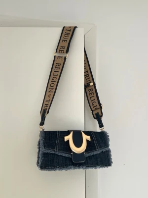 True Religion Cross body bag/clutch - Superfin. Bandet går att ta av så man kan bära som clutch, har liten repa på hästskon men inget som synd vid användning 