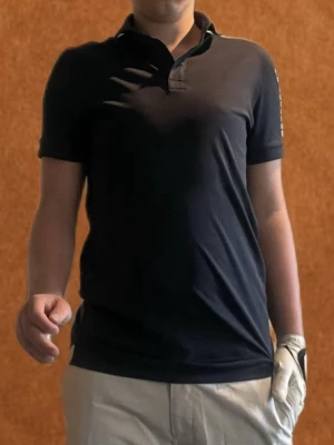 Svart golfpike från J.Lindeberg - Snygg svart golf piké från J.Lindeberg perfekt för en grich golfoutfit säljer för den blivit för liten nypris 899 mitt pris 400 skriv vid funderingar 