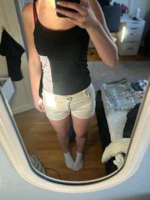 Beiga shorts med knapp och fickor - Snygga beiga shorts med knapp och dragkedja framtill samt klassiska fickor både fram och bak. Modellen är midwaist/lowwaist och har en enkel, stilren design som passar perfekt till sommaren. Materialet är stretchingt och tunt vilket gör shortsen perfekta i sommar💕säljer då de tyvärr inte kommer till användning. Skulle säga att de passar både en xxs och xs då de är stretchiga. 
