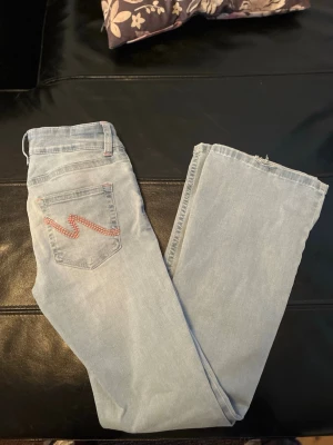 Ljusblå jeans från Nelly  - Snygga lågmidjade jeans från Nelly med broderade fickor. Stl 36 short 
