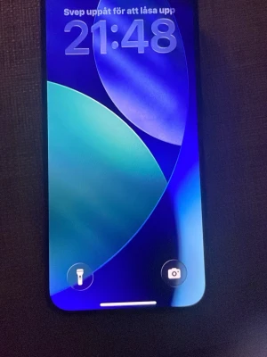 Svart iPhone med trippelkamera - Säljer en svart iPhone med stilren design och stor skärm. Telefonen har tre kameror på baksidan för grymma bilder och videos. Tillverkad i glas och metall, perfekt för dig som gillar modern teknik och snyggt utseende.