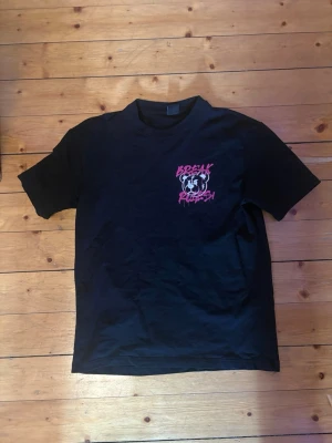 Svart t-shirt med rosa tryck - En tröja som inte har kommit till användning. Den är over size men i storlek xs. 