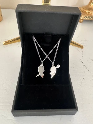Arrow heart necklace  -  Två matchande silver halsband med delade hjärthängen – perfekta att dela med en vän eller partner. Halsbanden är 100 % rost- och nickelfria. Kedjorna är 40 cm långa men kan förlängas med ytterligare 5 cm. Hör gärna av dig om du har några frågor ☺️