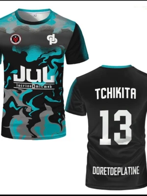 Svart och turkos sporttröja JUL - Unik sporttröja i svart, turkos och grått med coolt kamouflagemönster. Tryck på bröstet och ryggen med texten 'TCHIKITA 13' och 'DORETDEPLATINE'. Rund halsringning och korta ärmar. Perfekt för träning eller match.