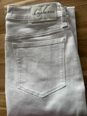 Vita skinny jeans från Calvin Klein - Snygga vita skinny jeans från Calvin Klein Jeans med klassisk femficksmodell och diskret CK-logga på bakfickan. Jeansen har hög midja och är tillverkade i stretchigt bomullsmaterial för en bekväm passform.