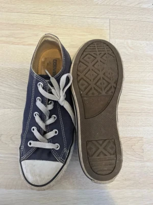 Converse skor  - Ett par marinblå converse skor i storleken 35 men skulle säga att dom är lite större. Syns att dom är väll använda men endå fint skick 