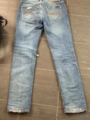 Nudie jeans - Ett par nudie jeans i modell gritty jackson. De är ett par gritty Jackson broken time som inte säljs längre. Slitningarna vid knäna är gjordes i fabrik och ser sjukt feta ut i användning. Strl W31 L34