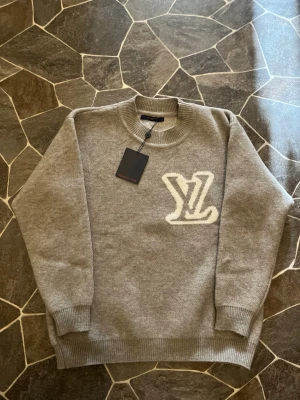 Grå Stickat Sweatshirt - En mycket fin aldrig använd sweatshirt i grå färg. Plagget har aldrig använts därmed i nyttskick. Tröjan köptes som en födelsedagspresent men var tyvärr för stor. Sitter som M-L därmed kan var lite bred.                 Priset kan diskuteras!