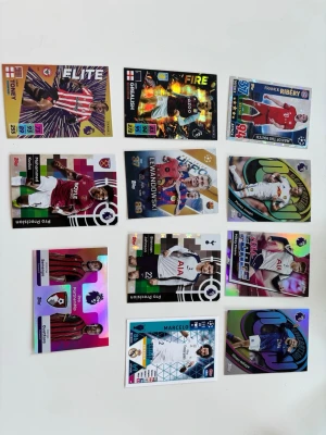 Samling fotbollskort Premier League - Säljer en samling färgglada fotbollskort från Premier League och andra ligor. Korten har holografiska effekter och visar spelare som Lewandowski, Grealish, Ribéry, Marcelo och andra spelare. Perfekt för dig som gillar att samla på sportkort och vill ha unika motiv i din samling. Skriv för fler specifika bilder på vardera kort, pris kan diskuteras. Alla kort är värda ungefär 15-25kr