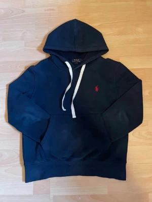 Mörkblå hoodie från Polo Ralph Lauren - Snygg mörkblå hoodie från Polo Ralph Lauren är jätte skön o är tyvärr nu för liten                                   Storlek M