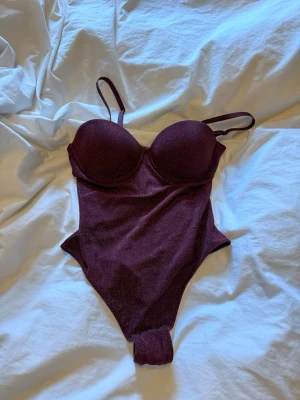 Vinröd glittrig body - Röd glitter body från intimissimi. Storlek 75b. Endast testad