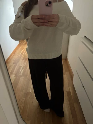 Vit off shoulder stickad tröja - Säljer en vit stickad tröja med off shoulder-modell och bred ribbad mudd vid ärmslut och nederkant. Tröjan har en avslappnad passform och är perfekt för dig som gillar en enkel men trendig stil. Materialet känns mjukt och bekvämt mot huden. Aldrig använd bara provad🤍🦄