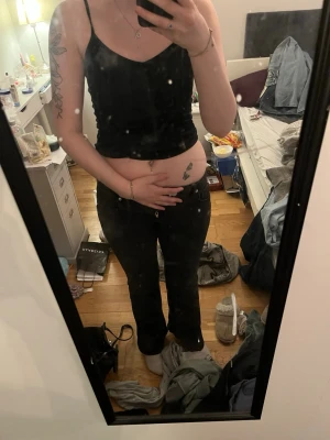 Svarta bootcut jeans - Säljer ett par svarta bootcut jeans med låg midja och klassisk femficksdesign. Jeansen har en snygg passform som sitter tajt över höfterna och blir vidare nedtill. Perfekta till en trendig och avslappnad stil.