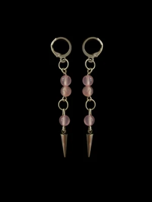 Silvriga örhängen med rosa pärlor - Säljer ett par långa örhängen med silverfärgade ringar och kedjor, dekorerade med tre ljusrosa pärlor på varje örhänge. Nederst hänger en spetsig metallkon som ger en edgy touch. Perfekta för dig som gillar unika accessoarer.