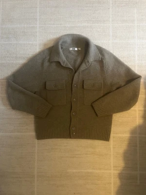 Trendig Uniqlo cardigan/overshirt - Riktigt snygg uniqlo cardigan som är helt slutsåld. Väldigt eftertraktad och i perfekt skick. Storlek XS, kan passa S, hör av er vid frågor eller funderingar priset går att diskutera!