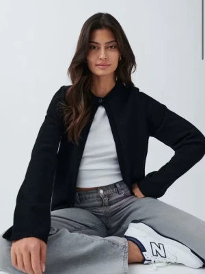 Svart stickad kofta från Gina Tricot - Snygg svart stickad kofta från Gina Tricot med rund halsringning och en knapp framtill. Koftan har en rak passform och långa ärmar, perfekt att slänga över en topp eller t-shirt. Enkel och stilren design som passar till det mesta.