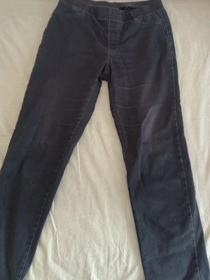 Svarta leggings med resårmidja - Säljer ett par svarta leggings med smal passform och bekväm resår i midjan. De är helsvarta och har en enkel, stilren design utan synliga detaljer eller mönster. Perfekta för dig som gillar en clean och basic look.