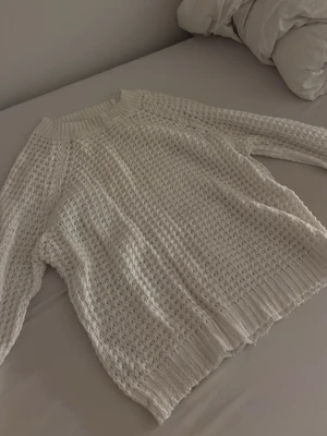 Vit chunky stickad tröja - Säljer en vit chunky stickad tröja med grovt hålmönster och bred ribbad kant vid hals, ärmslut och nederkant. Tröjan har en avslappnad passform och är perfekt för lager på lager. Materialet känns mjukt och den passar till mycket. Den är i strl M/38 men den passar mig som har strl Xs och S men den är fortfarande lite stor i storleken vilket vissa kan tycka om. Den är lite ”genomskinlig” så det kan va bra att ha något under om man vill. Den är från lager 157
