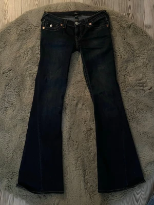 True religion jeans! - Säljer ett par jätte snygga True religion jeans i modellen Joey low rise flare och i storlek W26. Midjemått: 39 cm, innerbenslängd: 80cm. Lite defekter längst ner på benet (syns på sista bilden). Annars är jeansen i bra skick. (Pris kan diskuteras)💗