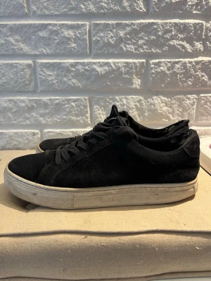 Svarta sneakers från Vagabond - Stilrena svarta sneakers i mocka med klassisk låg profil och vita sulor. Skorna har svarta skosnören och en enkel, tidlös design som passar till det mesta. Perfekta för dig som gillar en clean och avslappnad look.