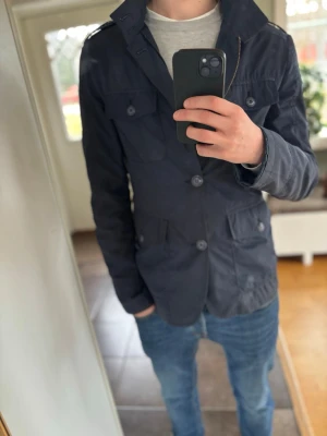 Mörkblå fieldjacket  - Snygg mörkblå fieldjacket, perfekt under vår/höst. Mycket bra skicka, väldigt stil ren. 