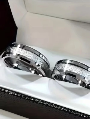 Silverfärgade ringar med mönster - Säljer två stilrena silverfärgade ringar i metall med ett snyggt, graverat mönster runt hela ringen. Raka kanter och blank finish ger en modern look. Perfekta för dig som gillar minimalistisk och elegant design. stainless steel