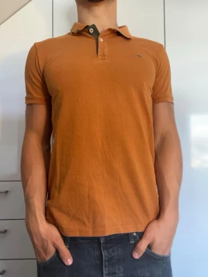 Orange pikétröja i bomull - Orange pike från Tom Tailor i 100% bomull. Strl S. Inga defekter. Modellen är 178 cm och väger 77 kg. Hör gärna av dig vid frågor!