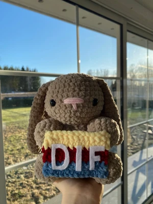Virkad DIF-kanin - En söt handgjord virkad kanin som håller en DIF flagga. Perfekt för dig som är en Djurgården älskare eller vill ha en unik dekoration.