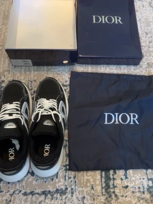 Skor - Snygga svarta sneakers med vita och grå detaljer samt vita skosnören. Tjock vit sula, på plösen och innersulan. Skorna har en sportig och modern design med mesh och läderpaneler.