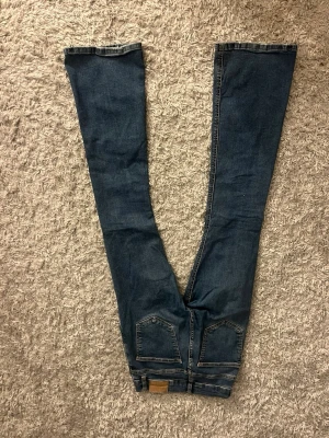 bootcut jeans/dżinsy - Säljer ett par mörkblå bootcut jeans med klassisk femficksdesign och smal passform. Jeansen är tillverkade i stretchigt denimtyg för extra komfort. Använda ett fåtal gånger.💕 bilderna blev upp och ned av nån konstig anledning