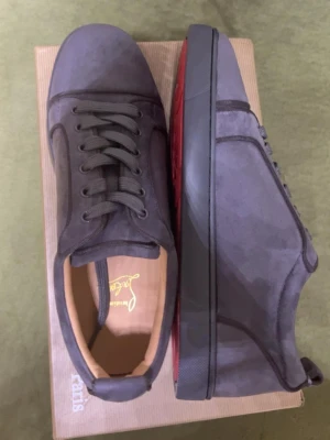Gråa sneakers från Christian Louboutin - Snygga grå sneakers från Christian Louboutin med klassisk röd sula. Det är storlek 43 och är helt nya med alla etiketter. Jag säljer dem för relativt billigt pris för dem inte passar.
