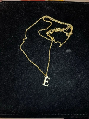 Guldplaterat halsband Stella Rose E - Guldplaterat halsband med bokstaven E som berlock. Säljer då jag fick den i present av en släkting som tog fel på bokstaven. Den är alltså i nyskick🫶🏼😊