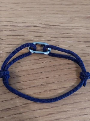 Blått justerbart armband  - Snyggt armband med blått snöre och en silverfärgad metallögla i mitten. HELT NYTT! Navy blå färg.
