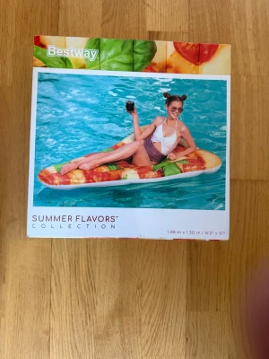 Uppblåsbar pizzabit från Bestway - Säljer en uppblåsbar madrass i form av en pizzabit från Bestway Summer Flavors Collection. Luftmadrassen har färgglada tryck med ost, tomat och basilika och mäter 1,88 x 1,30 meter. Perfekt för lata dagar i poolen eller på stranden. Aldrig använt. Kostar nytt 440kr nu för 200kr.