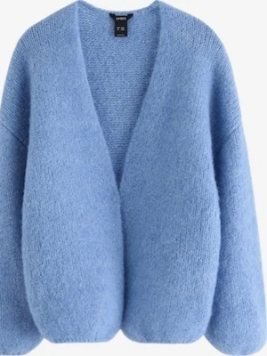 Lindex VANESSA blå cardigan - Mysig ljusblå kofta från Lindex i fluffigt stickat material. Koftan har en avslappnad passform, djup V-ringning och långa ärmar. Perfekt för lager på lager och ger en soft vibe till din outfit.