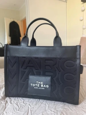 Svart Tote Bag från Marc Jacobs - Snygg svart handväska från Marc Jacobs  'The Tote Bag'. innerfack med plats för småsaker.      Väskan är använd max 3 gånger! 6500kr nypris. 