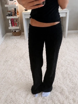 Mönstrade Svarta byxor - Ett par svarta loungewear-byxor med breda ben och resår i midjan. Byxorna är gjorda i ett mjukt, fluffigt material som sitter bra mot huden. Perfekta för att chilla hemma eller mysa runt i. Fint mönster💓                                                           Jag är ca 170cm och på mig sitter bra på längden💓