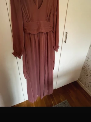 Lång rosa klänning med v-ringning - Säljer en långklänning från Bubbleroom. Aldrig använd, helt ny. Dragkedjan kan vara lite trög men man måste bara dra lite hårdare.